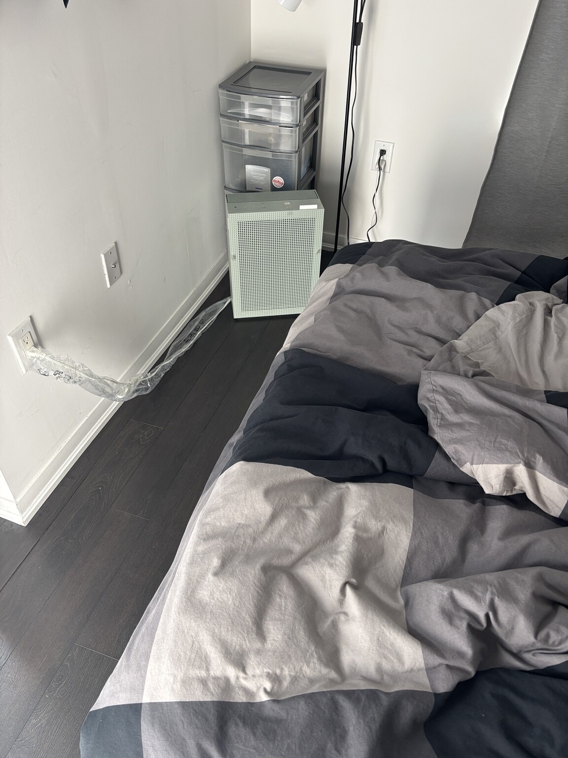 Sage green Coway Airmega 150C beside a bed in a small bedroom